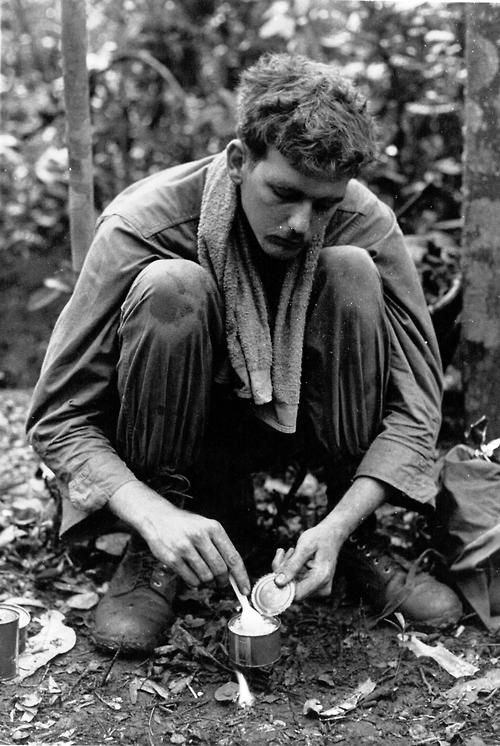 A soldier heats a can of C-rations over a burning chunk of C-4