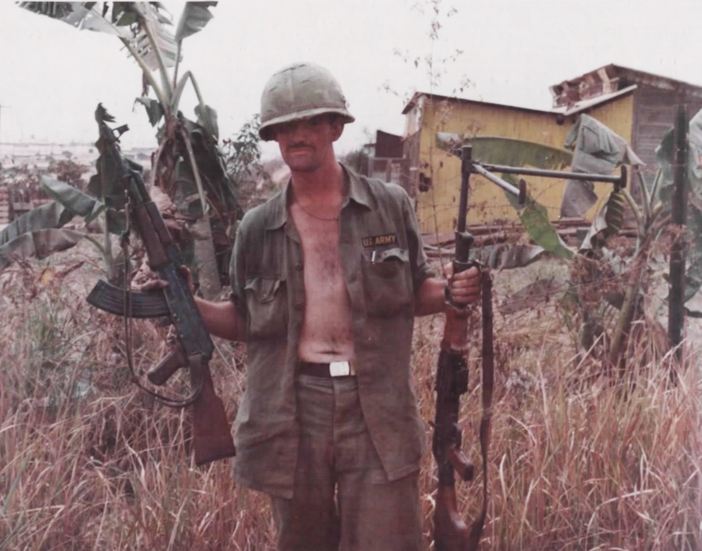 A 9th Infantry Division soldier holds a captured AK-47 and RPK