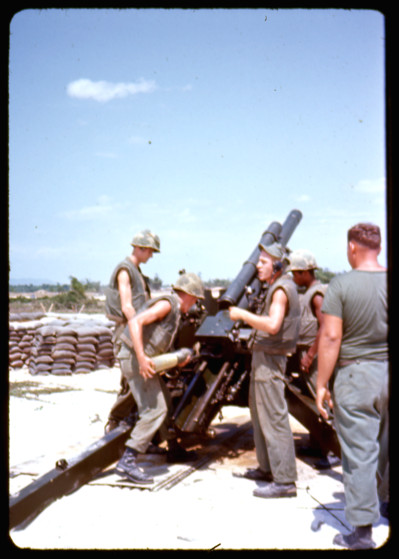 A 105mm howitzer crew loading a round, 1966